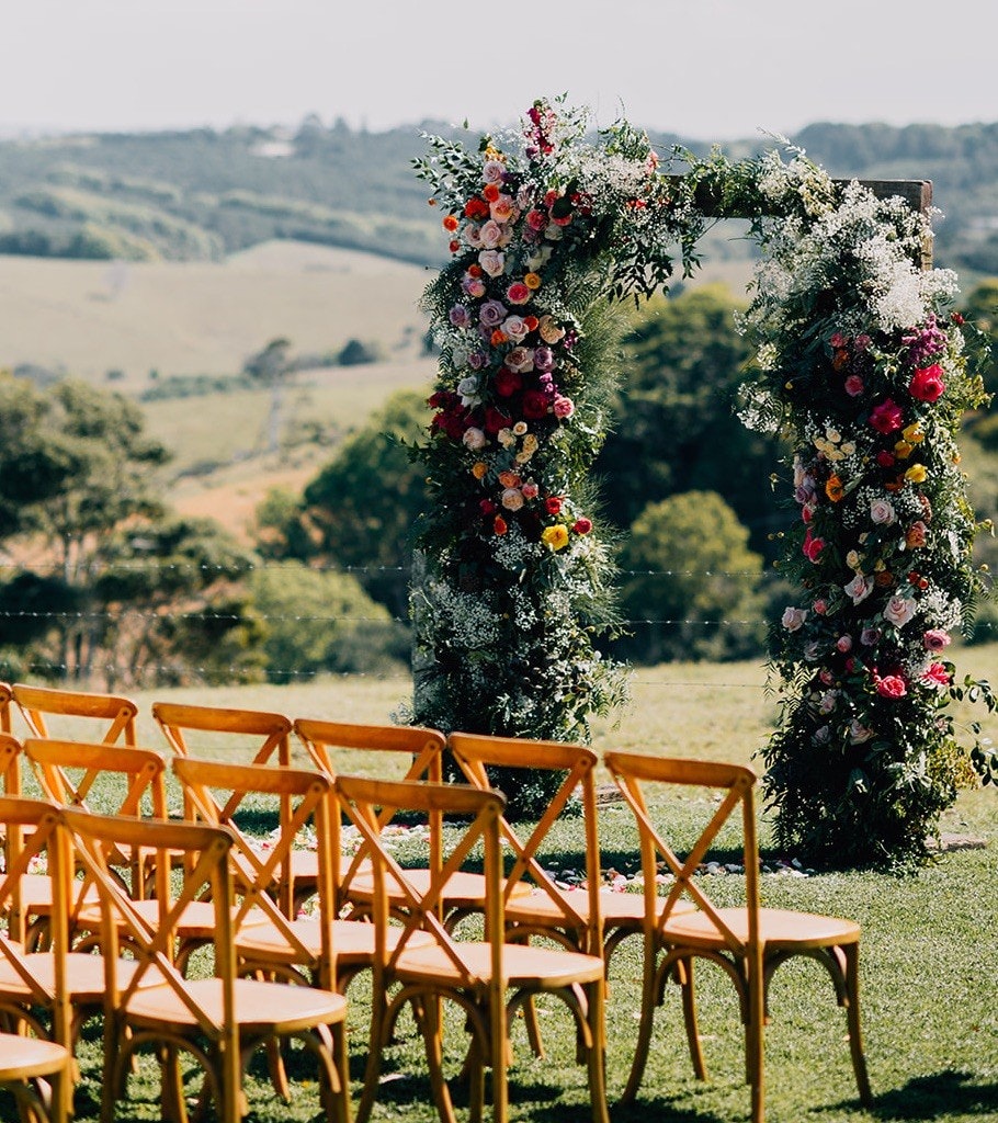 Decorative floral archway with a mountain view.